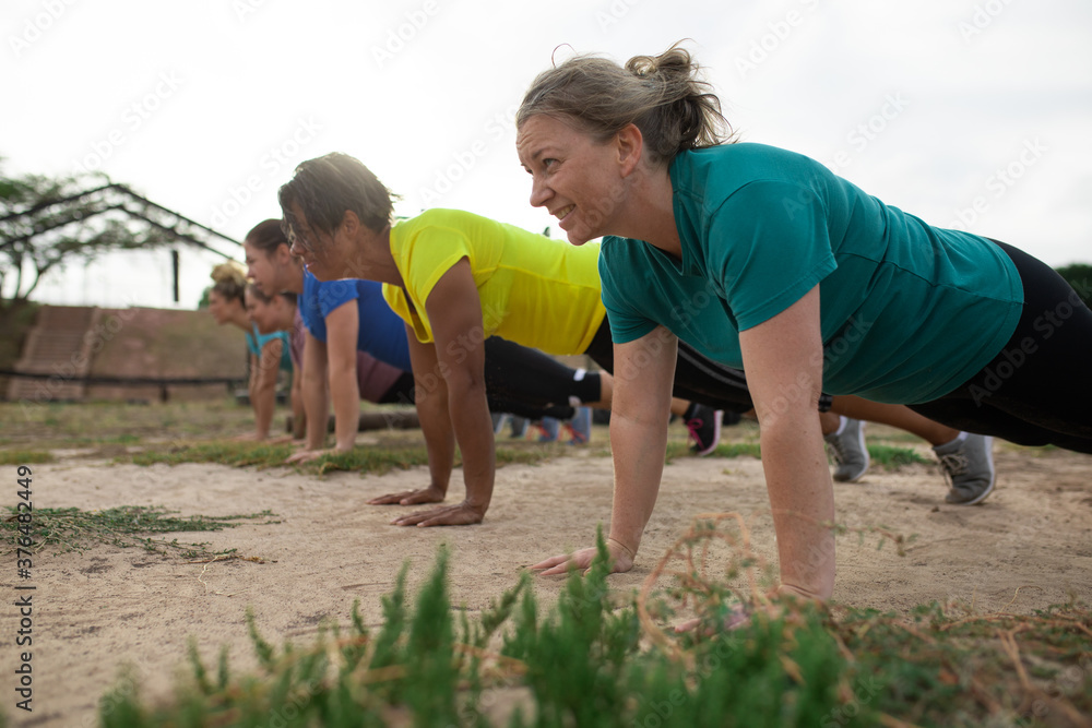 Group of woman performing push up exercise at boot camp Group of woman performing push up exercise at boot camp
