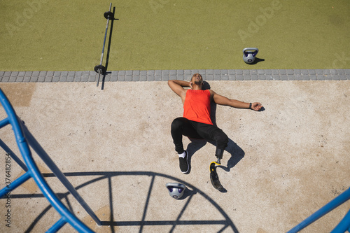 High angle view of man with prosthetic leg relaxing in park photo