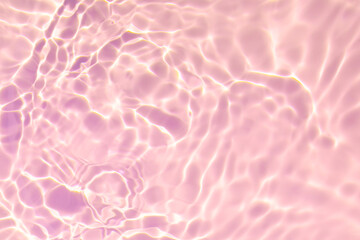 Closeup of pink transparent clear calm water surface texture with splashes and bubbles. Trendy abstract summer nature background. Coral colored waves in sunlight. Copy space.