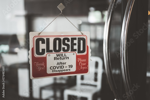 Closed sign in a shop showroom with reflections. sign showing the word " Closed ". Closing announcement concept Or stop the business, close the shop.