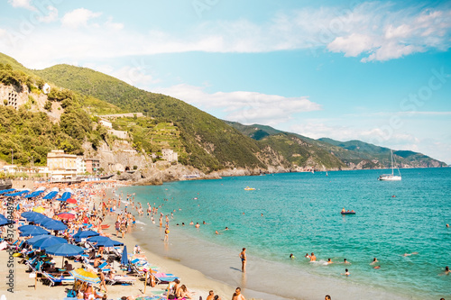 Monterosso al mare - 3 august 2020: town beach, a main italian summer tourist attraction in cinque terre national park, on liguria coast. Beachgouers enjoy turquoise waters