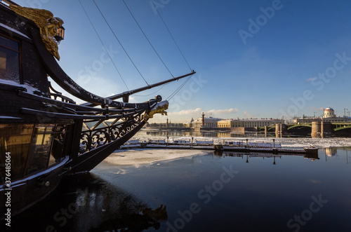 Flying Dutchman ship, floating ice and reflection on Neva river, Saint-Petersburg, Russia, Rostral columns, birzhevoy bridge