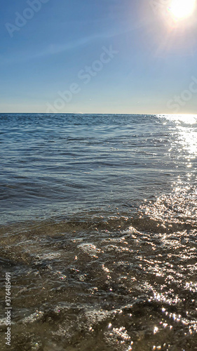 Seascape. Azure color of water  waves foaming on the shore. Selective focus. Summer rest.