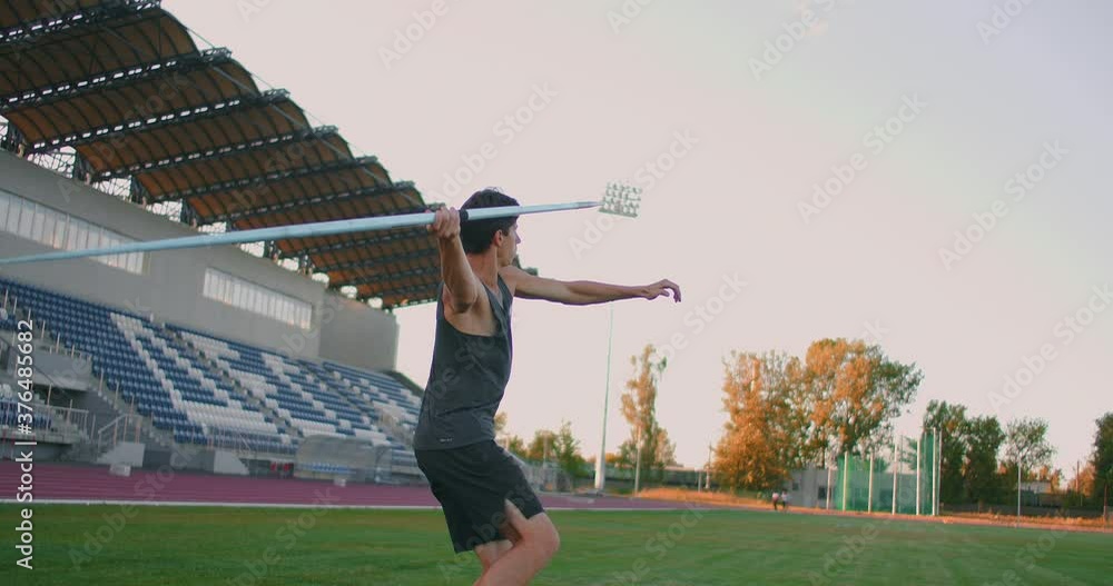 A male athlete throws javelins at a stadium in slow motion. Athletics