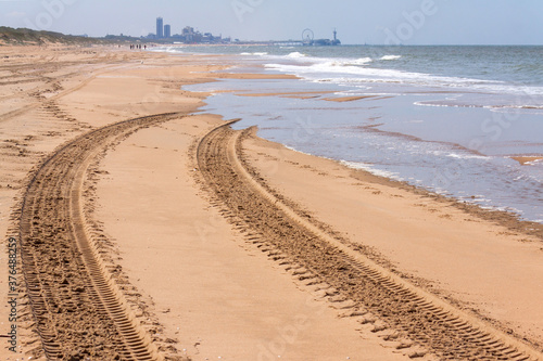 Car tracks on the beach, erased by upcoming tide