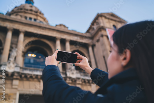 Unrecognizable woman tourist taking photos of old cathedral