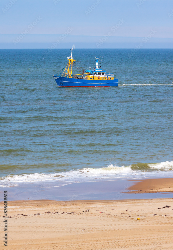 A shrimp trawler fishing along the beach of Wassenaar, Netherlands A shrimp trawler fishing along the beach of Wassenaar, Netherlands