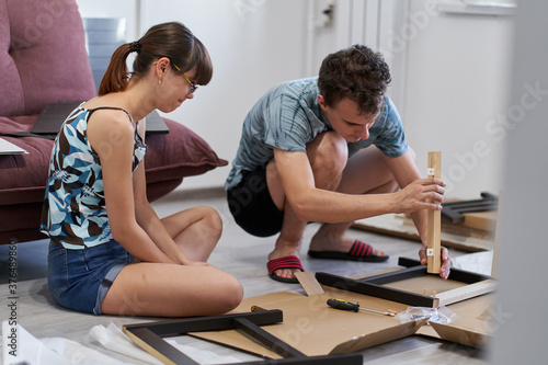 Young couple assembling their furniture