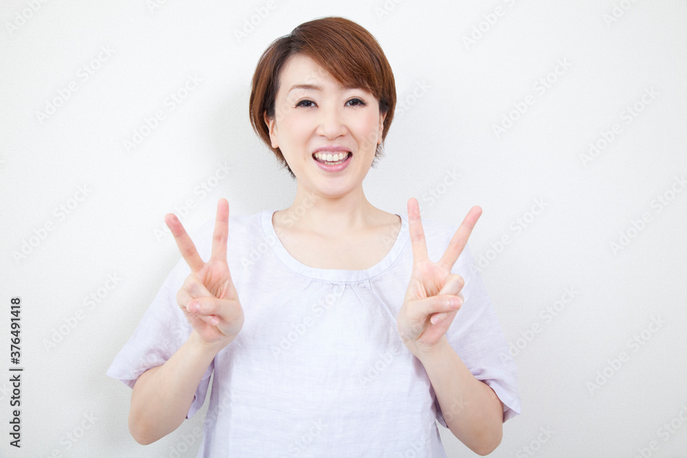 ピースサインをするミドル女性 ピースサインをするミドル女性
