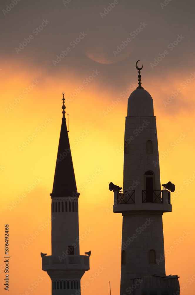 Obraz premium Minarets and the sun in the morning, a view from Busiateen coast, Bahrain