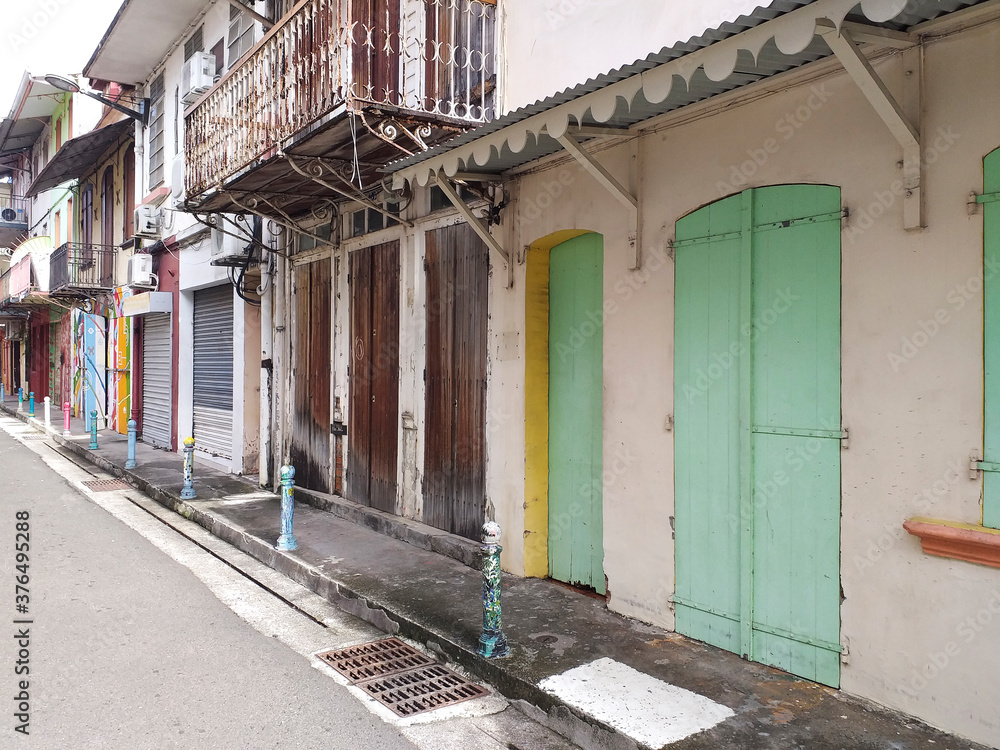 Obraz premium Typical Caribbean houses in street of tropical city. Architecture and construction of the French Antilles.