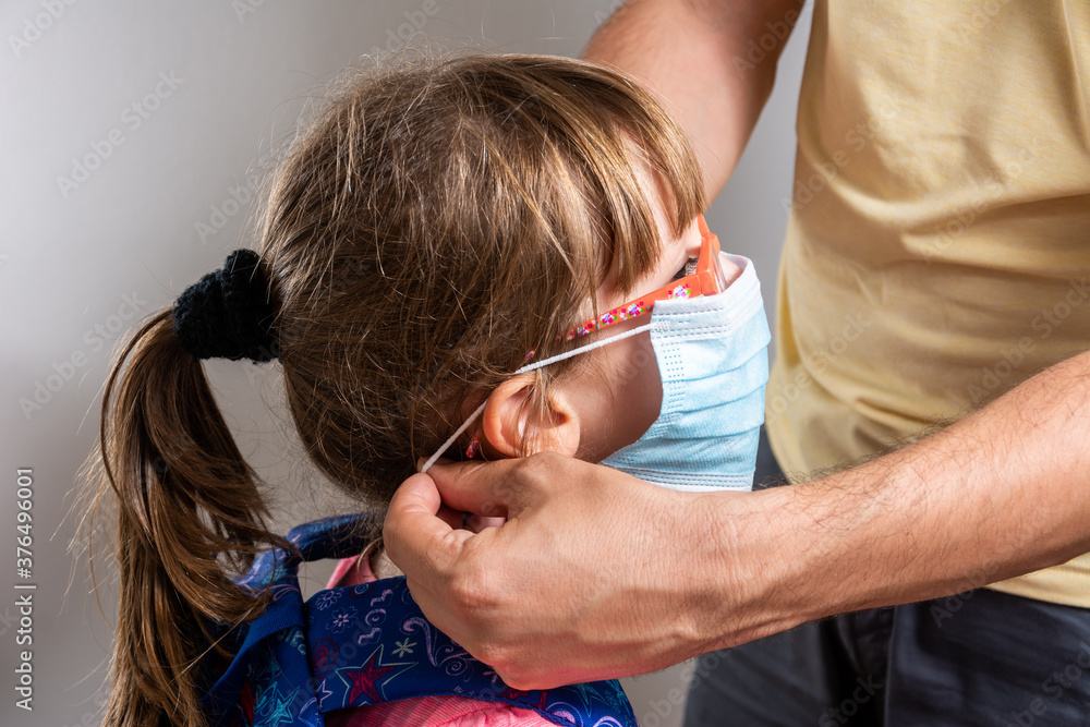 Fototapeta premium Coronavirus back to school reopening: Girls, children, students, with face masks. For Education, Health, Safety, and Environmental concepts regarding coronavirus, schools, and facemasks.