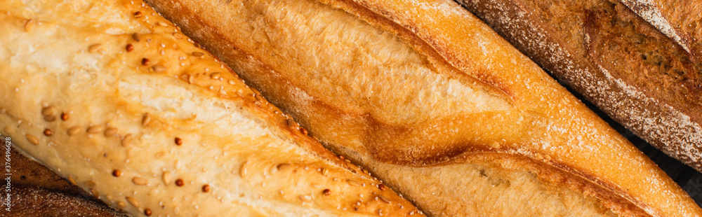 close up view of fresh baked baguette loaves, panoramic shot close up view of fresh baked baguette loaves, panoramic shot