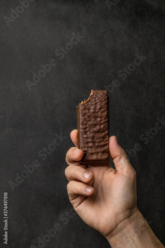 close up of a hand holding a chocolate bar