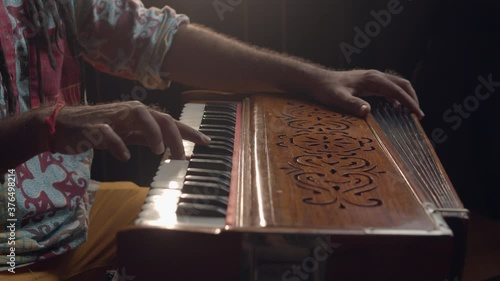 Hindi world. Creative people. Close up of an Indian man playing traditional instrument in the sound studio. Male person plays meditation music.