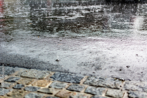flooded road during heavy rain. raindrops splashes background.