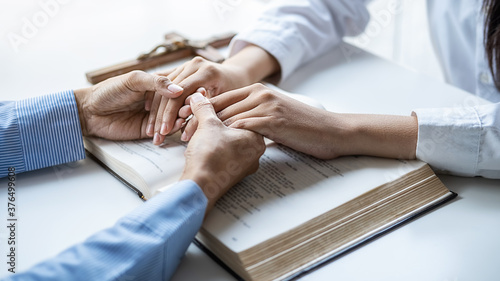 Christian woman praying with hands together on holy bible and wooden cross. Woman pray for god blessing to wishing have a better life and believe in goodness.