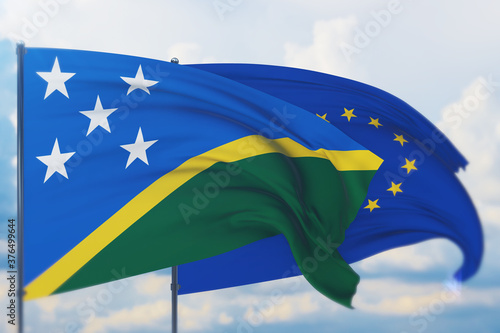 Waving European Union flag and flag of Solomon Islands. Closeup view, 3D illustration.