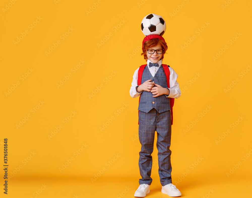 Fototapeta premium Confident schoolboy with football ball.