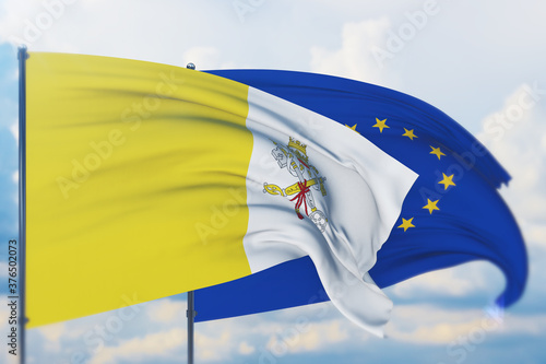 Waving European Union flag and flag of Vatican City. Closeup view, 3D illustration. photo