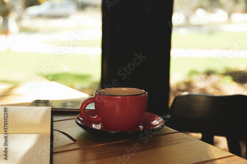 Cup of coffee, notebook and phone on wooden table