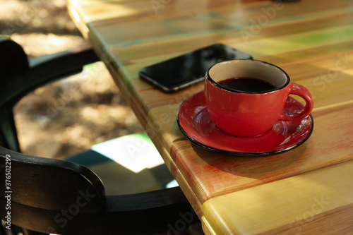 Phone and cup of coffee on wooden table