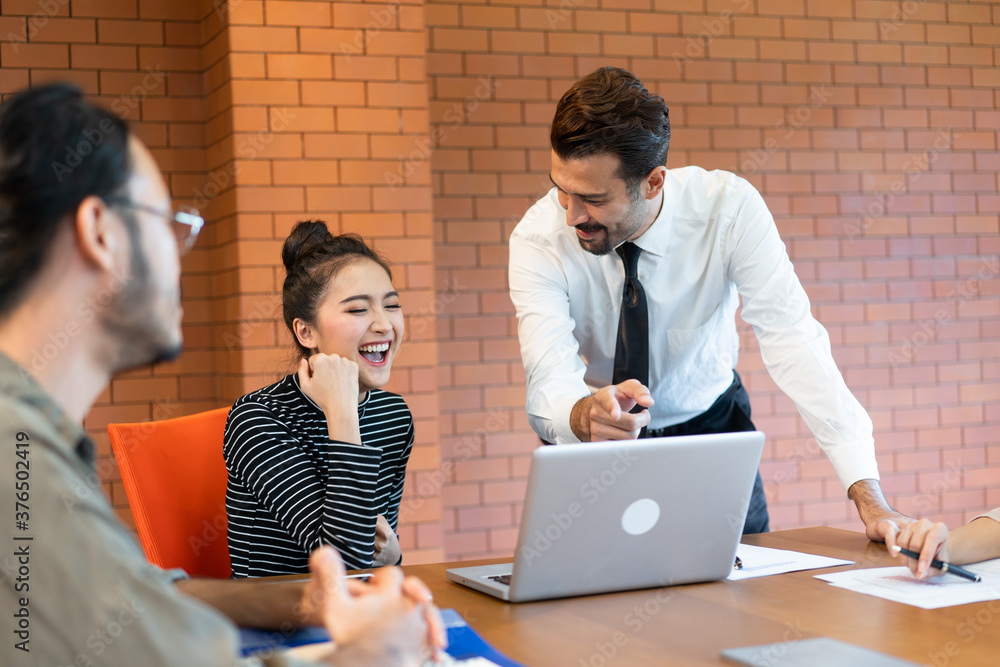 A young Asian business woman showed Extremely glad to hear the good news from a young manager amid an office meeting. A young Asian business woman showed Extremely glad to hear the good news from a young manager amid an office meeting.