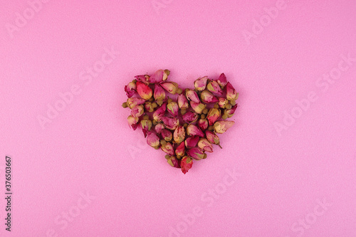 Heart of roses on a pink background. Flatlay.