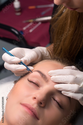 Beautician plucking eyebrows. Eyebrow care in a beauty salon.