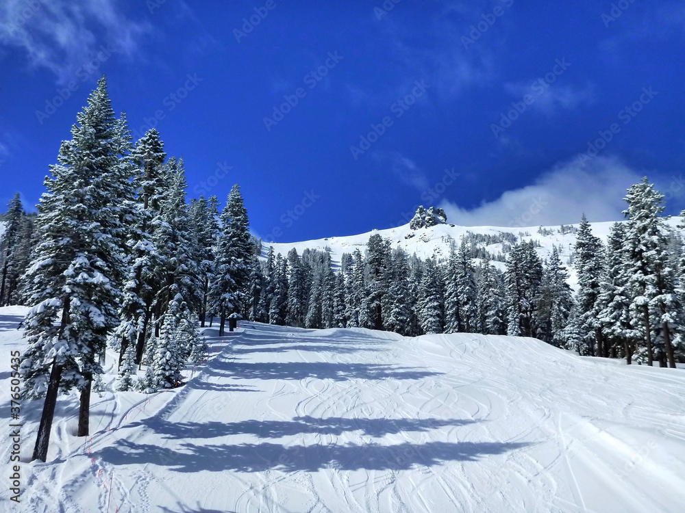 Obraz premium View of the snow covered ski slope at Kirkwood Mountain on a sunny winter day with vibrant blue skies