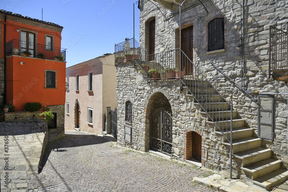 A narrow street among the old houses of Guardia Perticara, a rural village in the Basilicata region, Italy.
