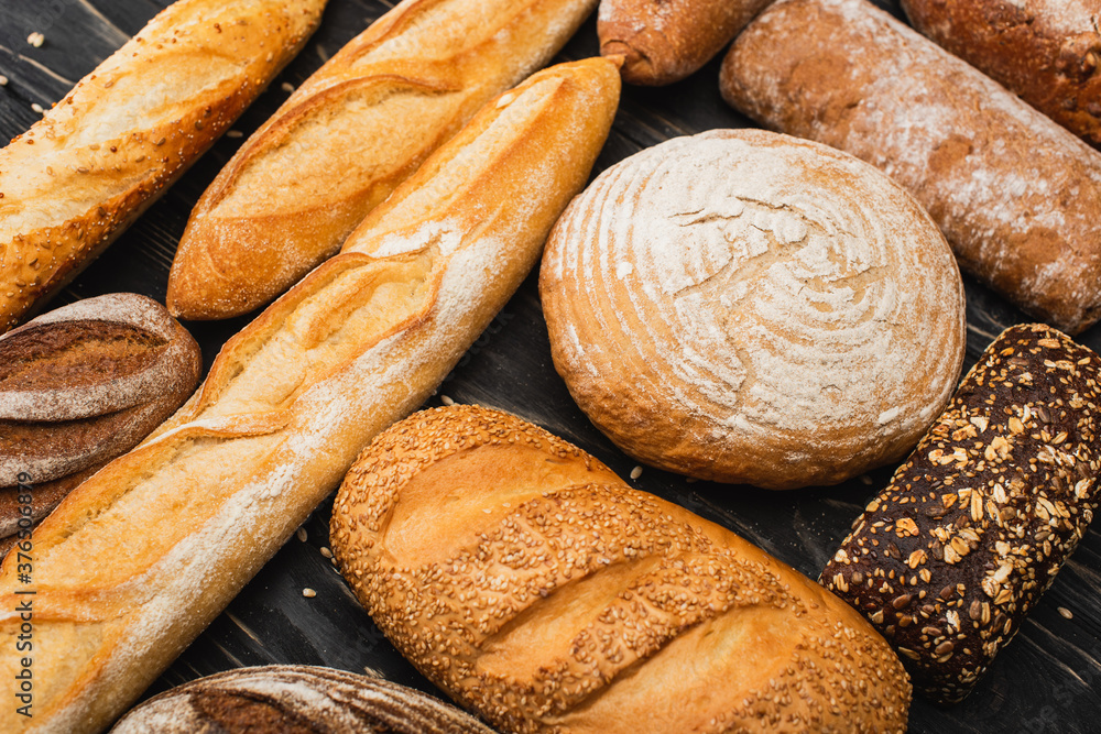 fresh baked bread loaves on wooden black surface