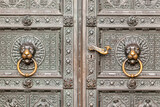 Decorative metal gate ornament. Antique iron door with classic ornaments. lion heads, Door knocker