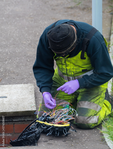 telephone engineer opening up a manhole and repairing a fault inside a waterproof casing 