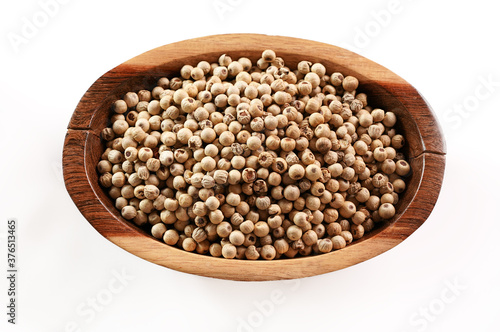 Dried white pepper corns in small wooden bowl - view form above isolated on white background