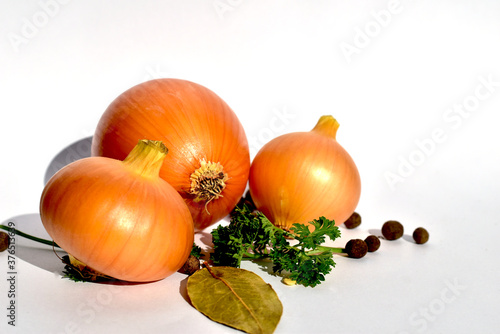 Three ripe onions were left on a white table.