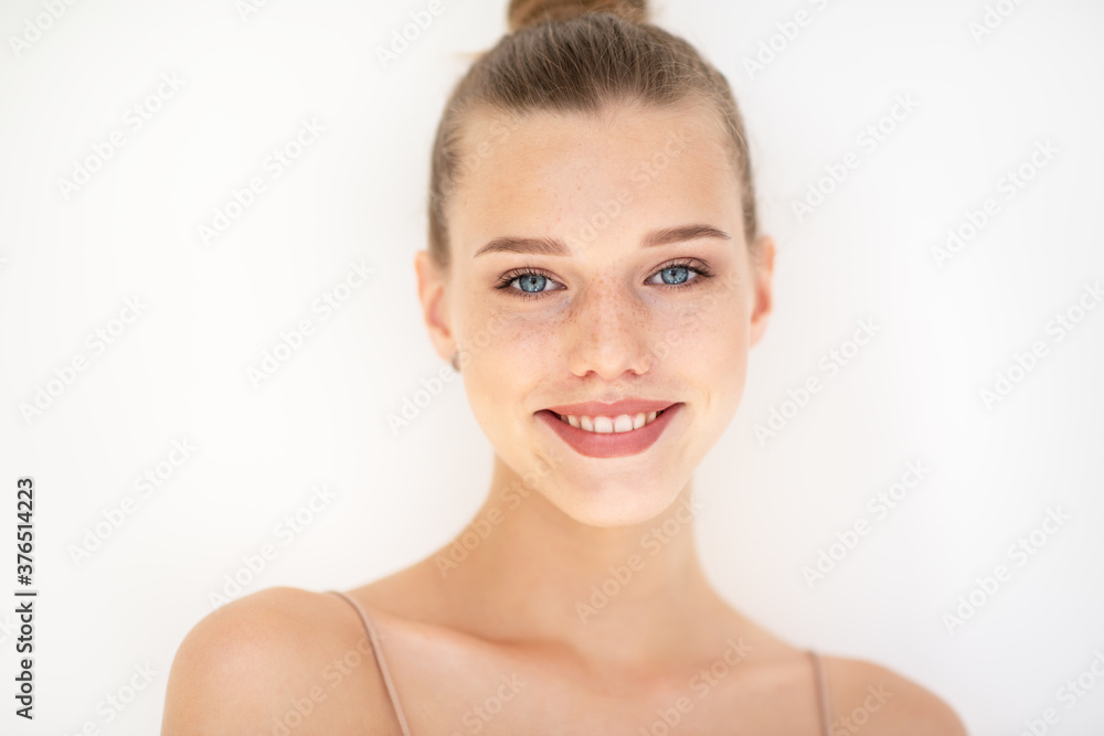 Portrait of beautiful woman with clean skin, youth concept, beauty treatment. Cheerful teen girl, beauty female face happy smiling and looking at camera over white background Portrait of beautiful woman with clean skin, youth concept, beauty treatment. Cheerful teen girl, beauty female face happy smiling and looking at camera over white background