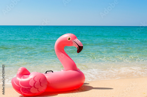 Pink inflatable mattress Flamingo on the beach close-up. The concept of tourism, travel, vacations. © kalfa