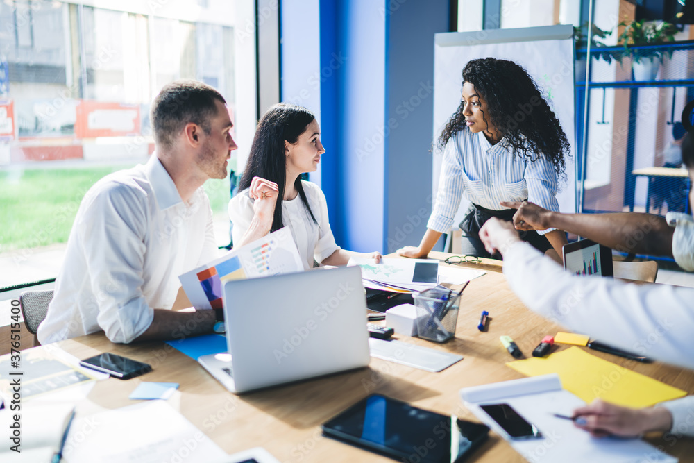 Businesswoman speaking to coworkers on meeting Businesswoman speaking to coworkers on meeting