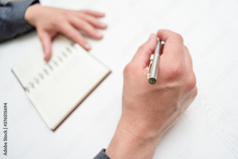 Businessman with pen is sitting by the desk close up. Businessman with pen is sitting by the desk close up.