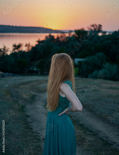 the girl looks at the sunset
