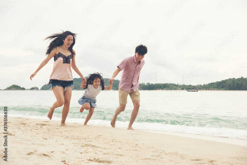 Asian family having fun running on a sandy beach. Happy asia family Having Fun In Sea On Beach Holiday. father mother and daughter happiness holding hand and running. people travel concept. Asian family having fun running on a sandy beach. Happy asia family Having Fun In Sea On Beach Holiday. father mother and daughter happiness holding hand and running. people travel concept.