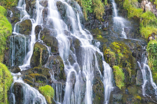 View of Bride Veil waterall on the Isle of Skye, Scotland. Beautiful collection of many smaller falls flowing in different directions. Fern and blooming heather around