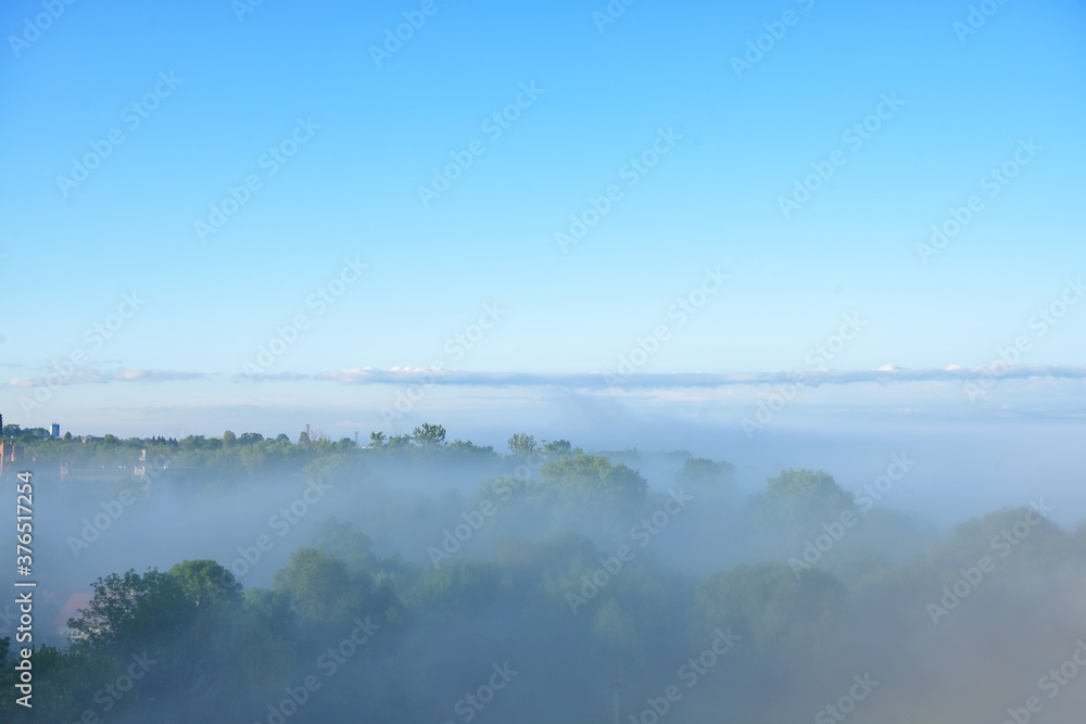 Background with visible silhouettes through the morning colorful fog. Wide outdoor background