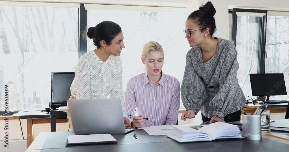 Multi ethnic 35s women colleagues led by company female ceo work together on financial stats report, do paperwork, make sales result analysis, forecasting gather in coworking office. Teamwork concept Multi ethnic 35s women colleagues led by company female ceo work together on financial stats report, do paperwork, make sales result analysis, forecasting gather in coworking office. Teamwork concept