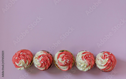 Top view festive cupcakes with pink cream and sprinkles.