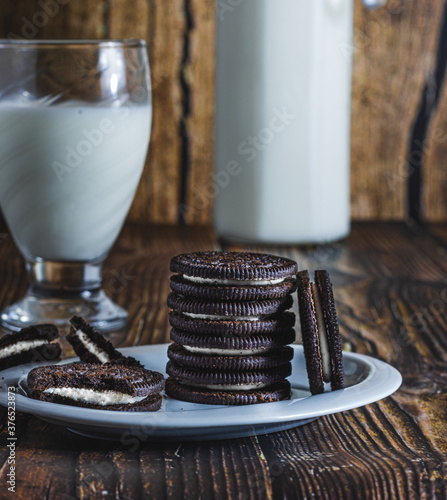 delicious milk chocolate cookies on a wooden table with a glass