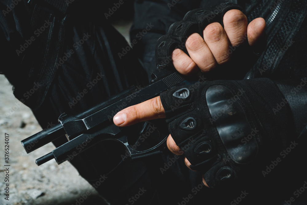 Close up of special forces soldier reloading his gun. Preparing to attack concept.
