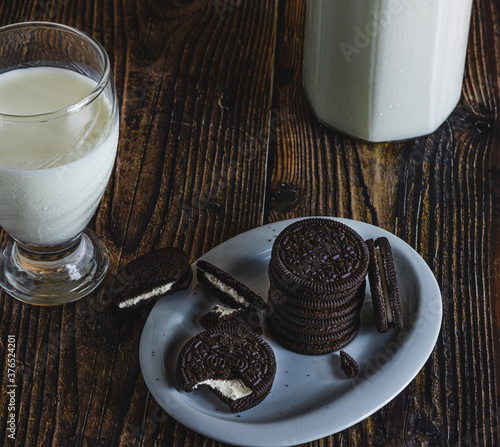 delicious milk chocolate cookies on a wooden table with a glass