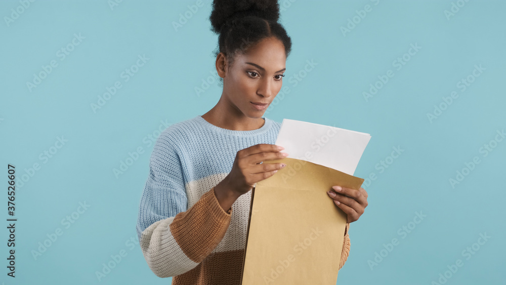 Beautiful african american girl intently looking at exams results over colorful background Beautiful african american girl intently looking at exams results over colorful background